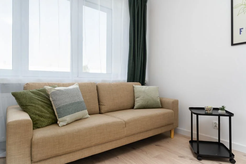 why-choose-us-03 Un jeune homme souriant range des cartons dans un salon moderne.